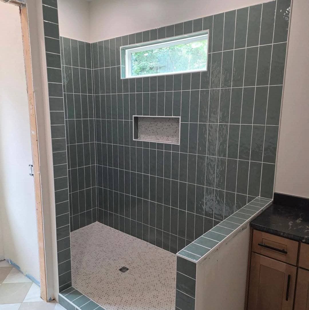 Walk-in shower before renovation — original tile